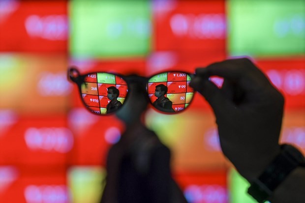 Employees pass a screen displaying stock movements at the Indonesia Stock Exchange building in Jakarta on March 2, 2020. (Photo: Antara)