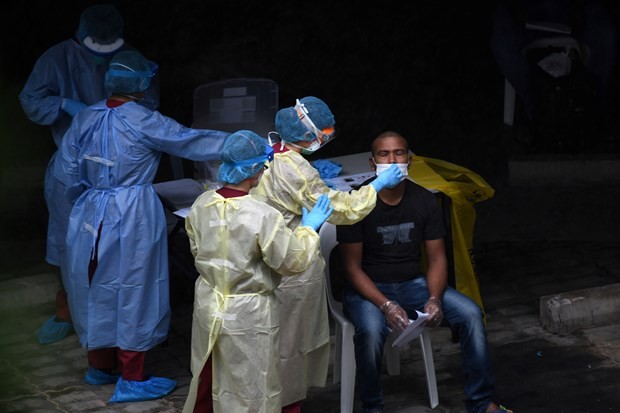 A foreign worker in Singapore has his sample taken for COVID-19 testing on April 27 (Photo: AFP/VNA)