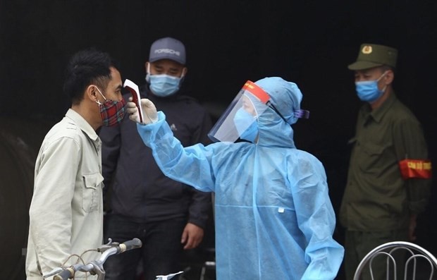 A man has his body temperature checked. (Photo: VNA)