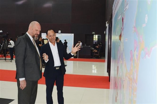 A Vietnamese business representative talks to a foreign partner about the Da Nang FTZ at the ceremony. (Photo: VNA) vietnam-establishes-first-free-trade-zone-in-da-nang-2.jpg