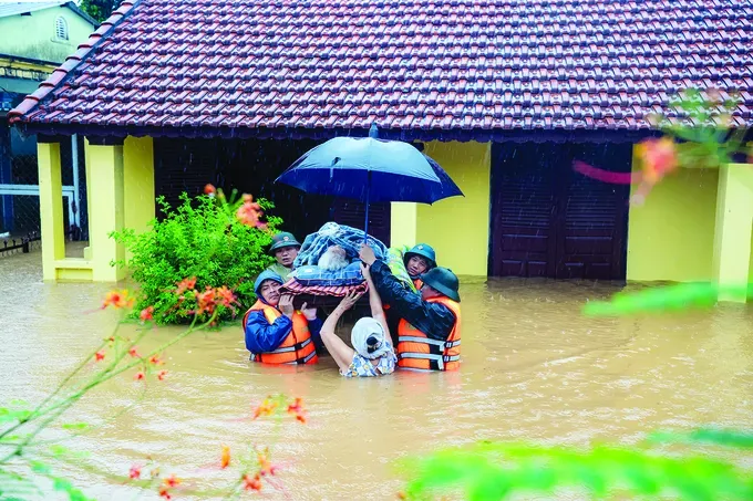 Authorities evacuate an elderly resident from a flooded house in Hue City on October 27 afternoon. (Photo: SGGP) 1b-9346-6290.jpg