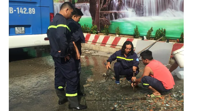 Lực lượng CS PCCC Q1 phối hợp nhân viên của Công ty cấp nước Bến Thành đang khắc phục sự cố. 