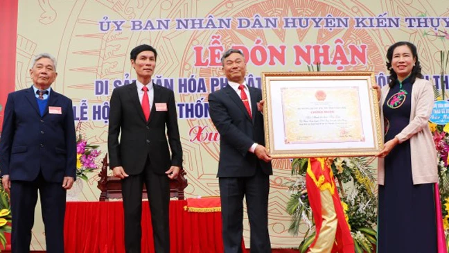 Bà Đặng Thị Bích Liên, Thứ trưởng Bộ Văn hóa Thể thao và Du lịch, trao Bằng công nhận “Di sản văn hóa phi vật thể quốc gia Hội Minh Thề” cho lãnh đạo huyện Kiến Thụy. Ảnh: Minh Thu-TTXVN