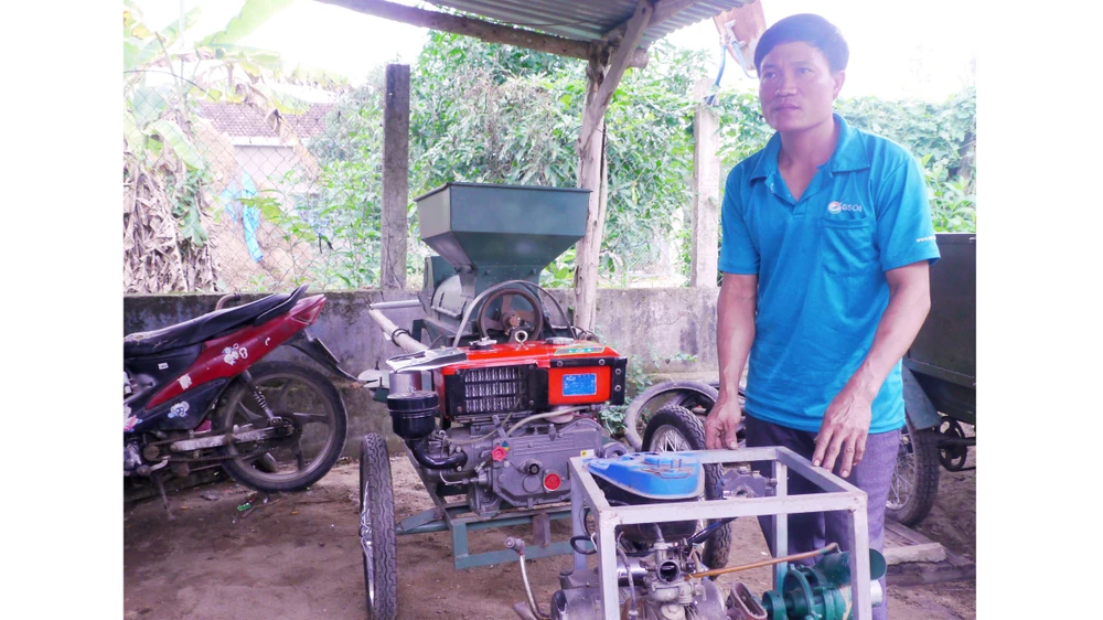 “Kỹ sư làng” Lê Văn Thành bên máy tách hạt bắp do anh sáng chế