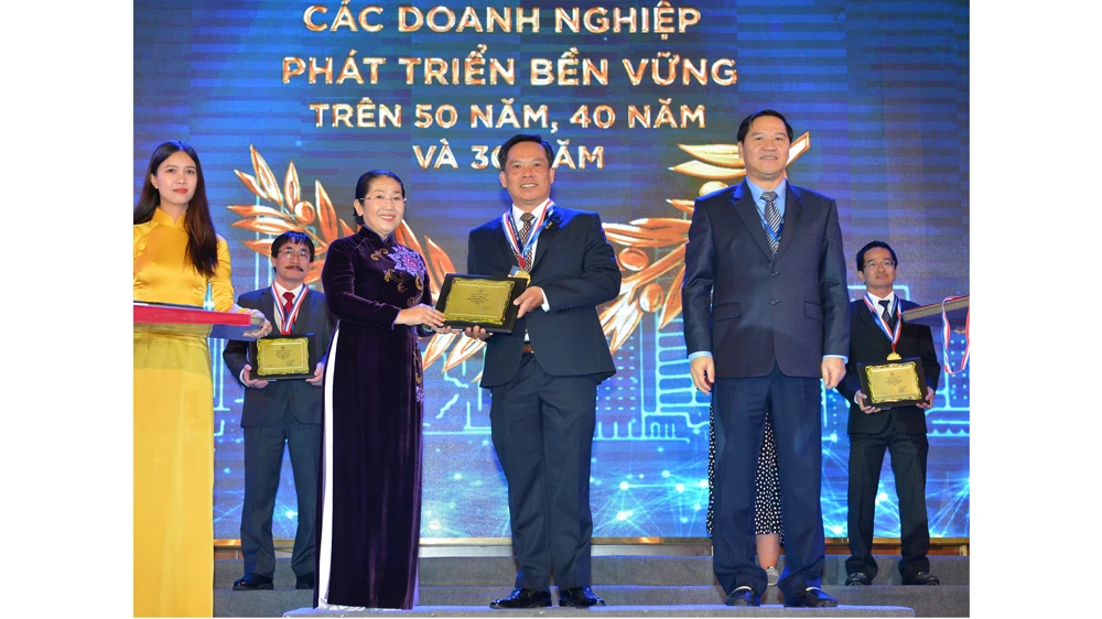 Phó Bí thư Thành ủy TPHCM Võ Thị Dung chúc mừng các doanh nghiệp phát triển bền vững trên 50 năm. Ảnh: Việt Dũng