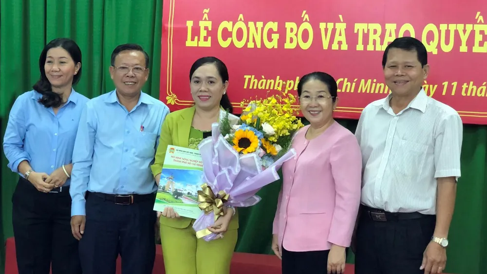 Đồng chí Võ Thị Dung trao quyết định và tặng hoa chúc mừng đồng chí Nguyễn Thanh Xuân. Ảnh: THÁI PHƯƠNG