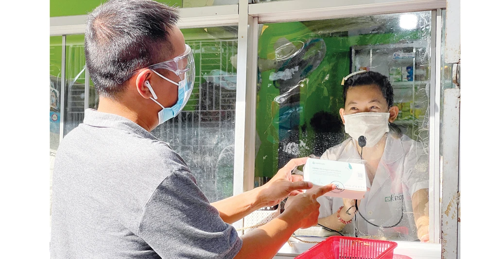 Anh Phú Trần (quận 3, TPHCM) mua dụng cụ test nhanh virus SARS-CoV-2 để sử dụng tại nhà chiều 6-8. Ảnh: HOÀNG HÙNG
