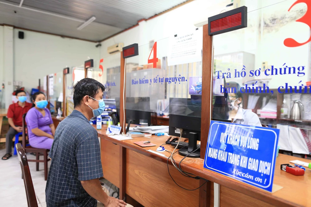 Người dân đến liên hệ làm giấy tờ tại UBND phường Hiệp Thành, quận 12, TPHCM. Ảnh: DŨNG PHƯƠNG