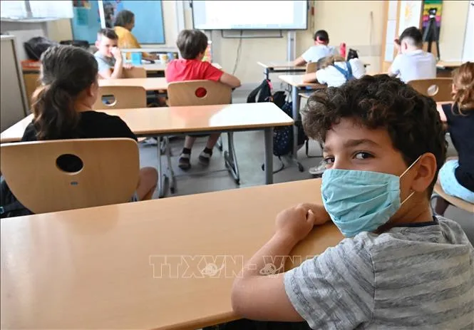Học sinh đeo khẩu trang phòng lây nhiễm COVID-19 tại trường học ở châu Âu. Ảnh: AFP/TTXVN
