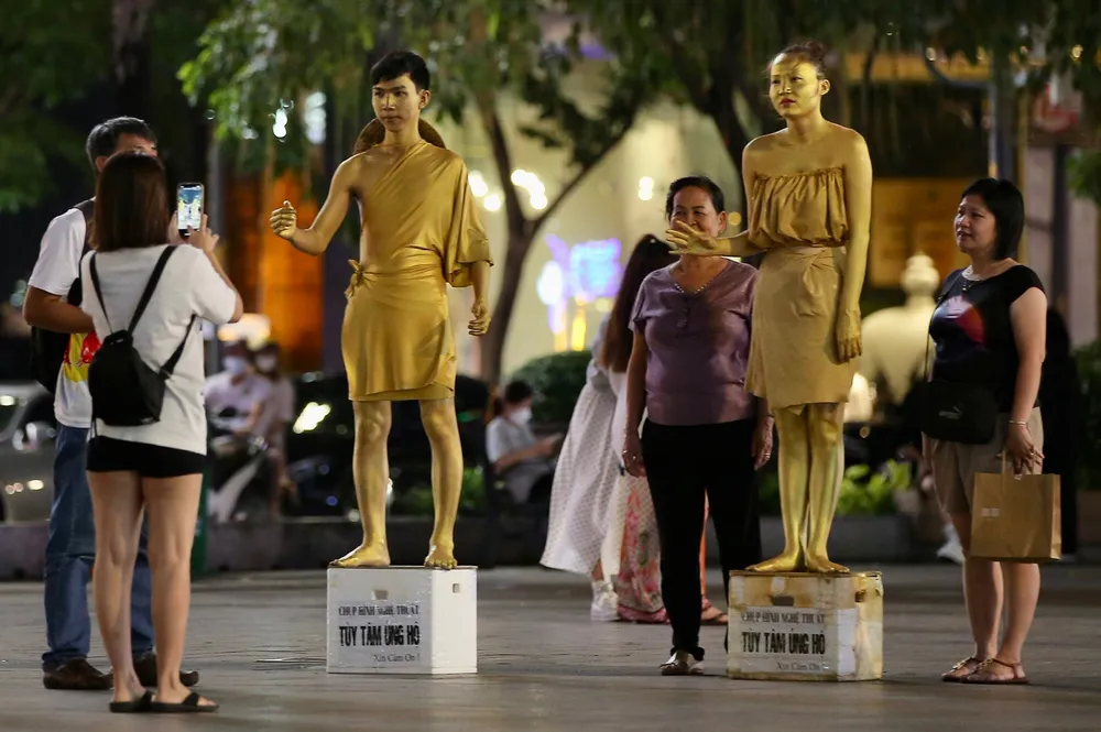 Người dân, du khách chụp hình với nhân tượng tại phố đi bộ Nguyễn Huệ. Ảnh: DŨNG PHƯƠNG