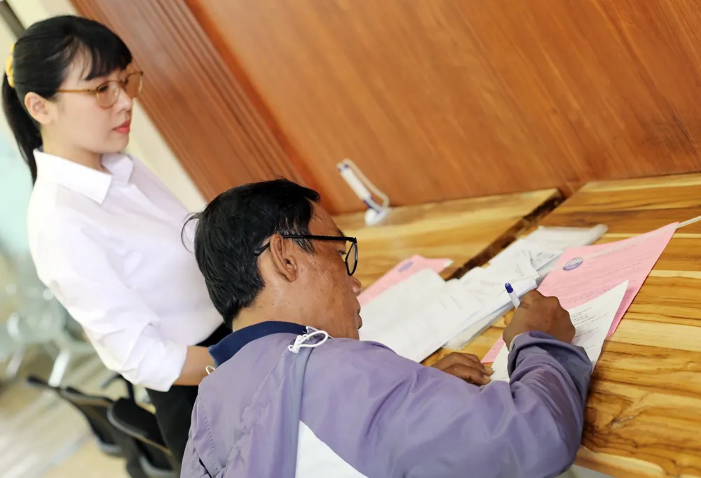 Nhân viên Công ty CP Cấp nước Bến Thành hướng dẫn người dân bổ sung hồ sơ cấp mới đồng hồ nước qua ứng dụng VNeID