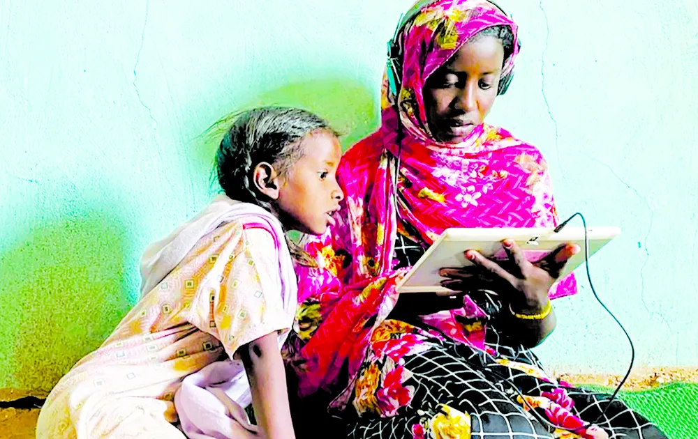 Các bé gái sử dụng máy tính bảng tại trung tâm học trực tuyến ở Jabalain, Sudan