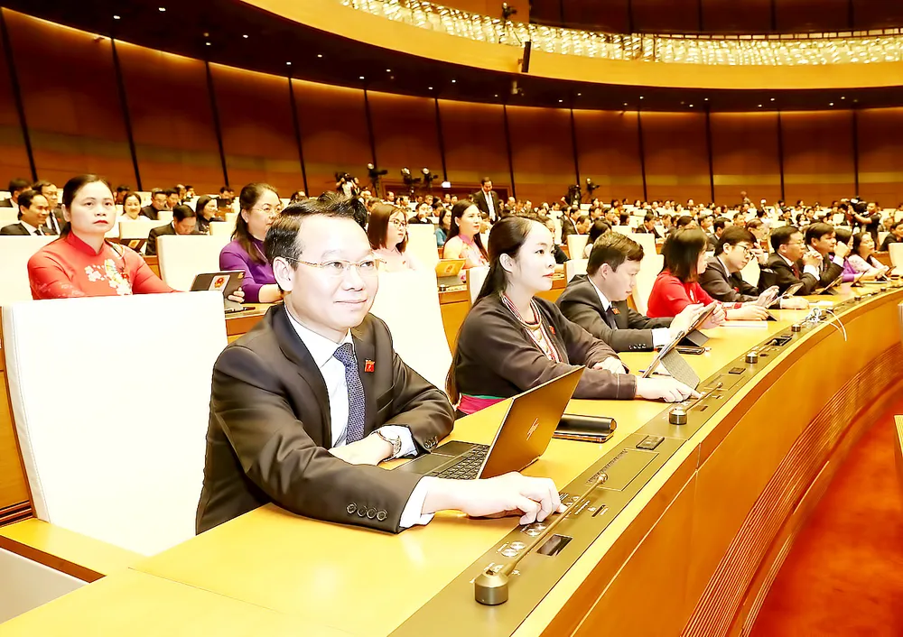 Các đại biểu Quốc hội bấm nút thông qua nghị quyết. Ảnh: QUANG PHÚC