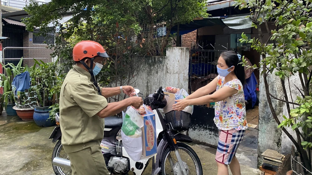 Người dân "vùng xanh" ở quận Tân Bình nhận quà tặng từ Công an quận Tân Bình. Ảnh: CAO THĂNG