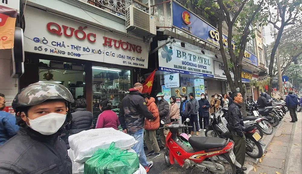 Nhiều người sẵn sàng xếp hàng chờ đợi cả tiếng đồng hồ để mua được cặp bánh chưng, hay cân giò, chả ưng ý tại cửa hàng Quốc Hương. Ảnh: NGUYỄN QUỐC