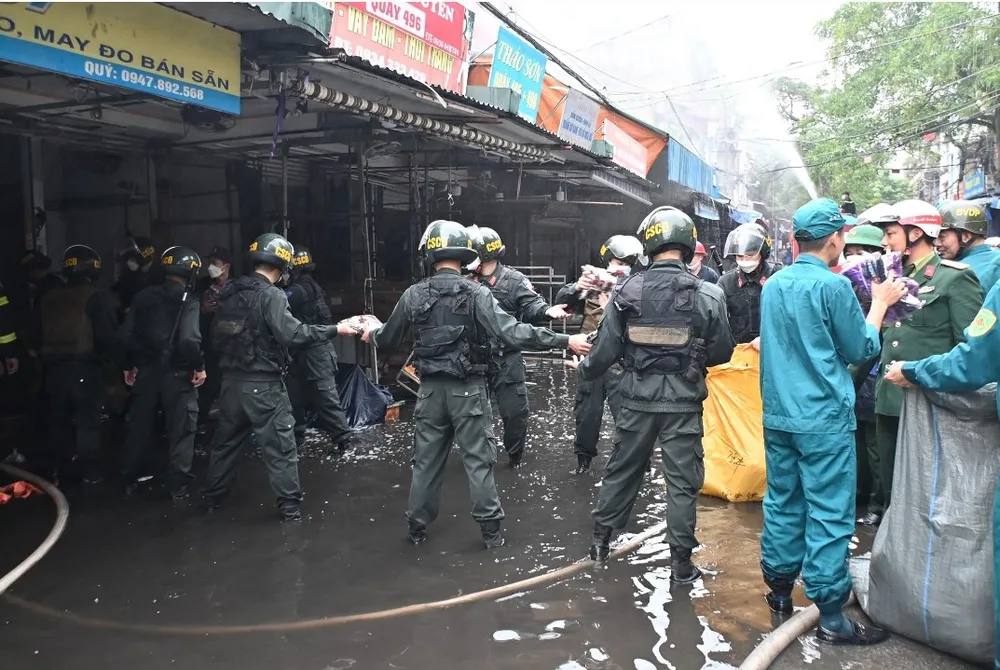 Các lực lượng chức năng đang hỗ trợ giúp đỡ các hộ kinh doanh tại chợ Tam Bạc di dời hàng hóa