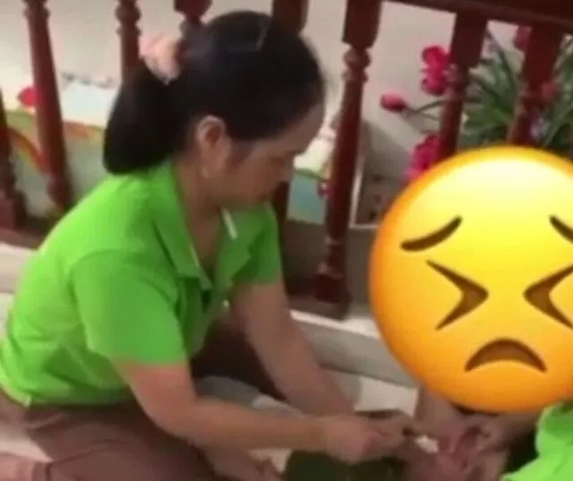 Hình ảnh cắt ra từ clip bảo mẫu cơ sở Tâm An đè trẻ tự kỷ ra sàn nhà để nhồi cơm