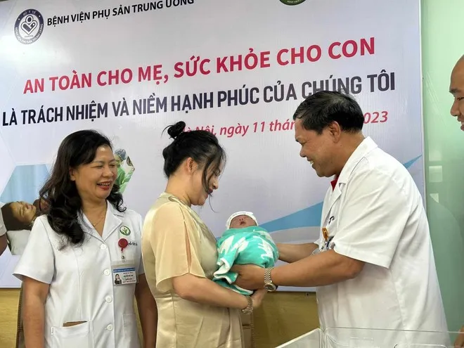 Ông Trần Danh Cường, Giám đốc Bệnh viện Phụ sản Trung ương trao cháu bé cho gia đình sau khi được các bác sĩ điều trị, nuôi dưỡng qua giai đoạn nguy hiểm
