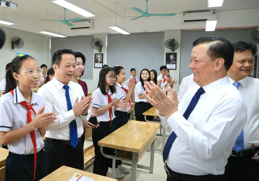 Đồng chí Đinh Tiến Dũng chúc mừng và trò chuyện với học sinh Trường THCS Ngô Quyền nhân dịp khai giảng năm học mới. Ảnh: VIẾT CHUNG