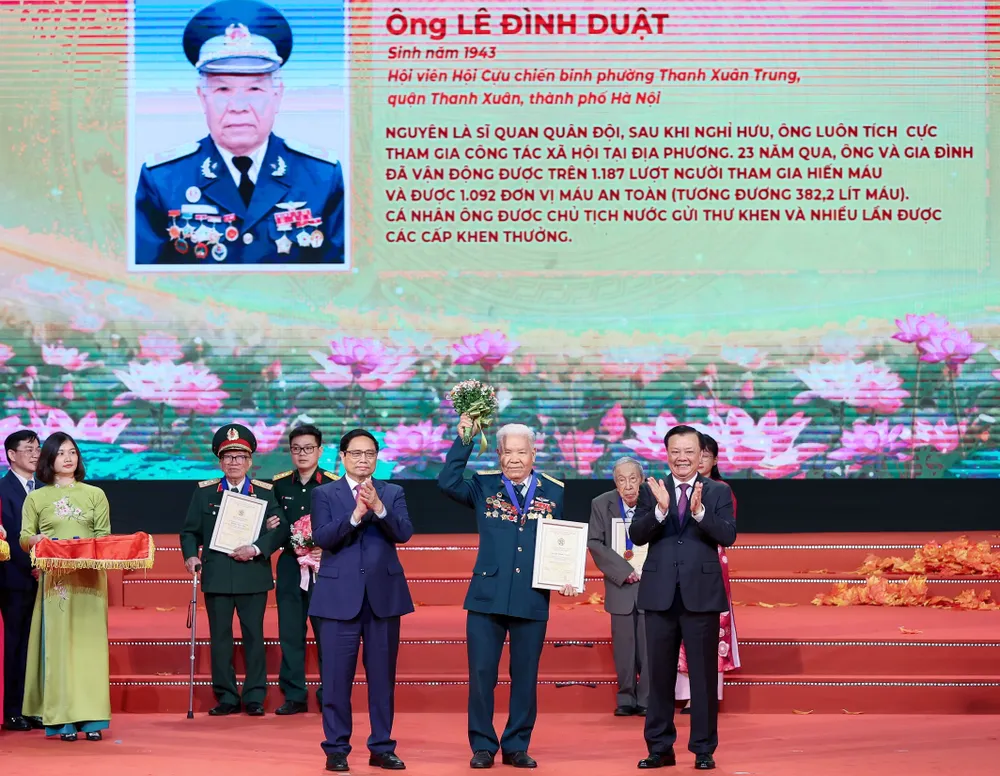 Thủ tướng Chính phủ Phạm Minh Chính và Bí thư Thành ủy Hà Nội Đinh Tiến Dũng trao danh hiệu &quot;Công dân Thủ đô ưu tú&quot; cho ông Lê Đình Duật. Ảnh: VIẾT CHUNG
