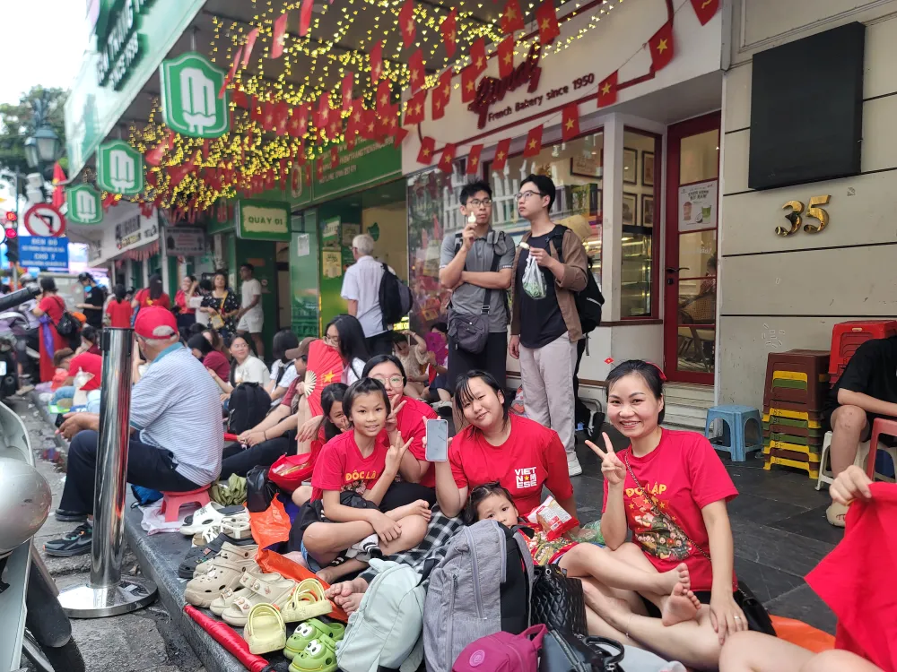 Một gia đình tới phố Tràng Tiền từ rất sớm để chờ xem tổng duyệt. Ảnh: QUỐC KHÁNH 20250829_171155(0).jpg