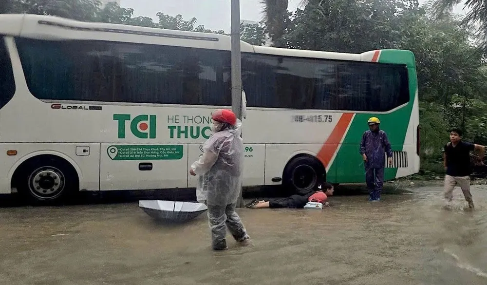 Một người đi đường bị điện giật làm ngã xuống đường ở khu vực Tú Mỡ - Phạm Hùng. Ảnh: CACC 33.jpg