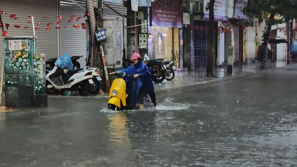 আজ ভোরে হ্যানয়ে ভারী বৃষ্টিপাতের ফলে বন্যা দেখা দেয়, যার ফলে মানুষের চলাচল করা কঠিন হয়ে পড়ে। ছবি: ভিয়েতনাম আনহ z7089137042712_b73cc6921b233d4b8e348f46facfeaf6.jpg