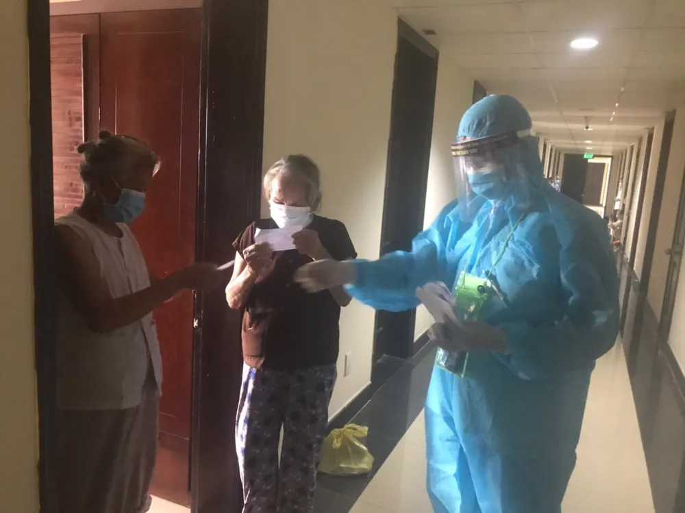 Đo thân nhiệt và trao tận tay phiếu cử tri bầu cử đại biểu Quốc hội và Hội đồng nhân dân các cấp nhiệm kỳ 2021-2026 cho từng công dân đang cách ly tập trung 