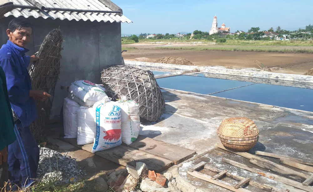 Muối làm ra khó tiêu thụ, ông Lê Doãn Sơn (62 tuổi, ở xã Hộ Độ) phải đóng muối vào các bao bì với hy vọng có thương lái đến mua