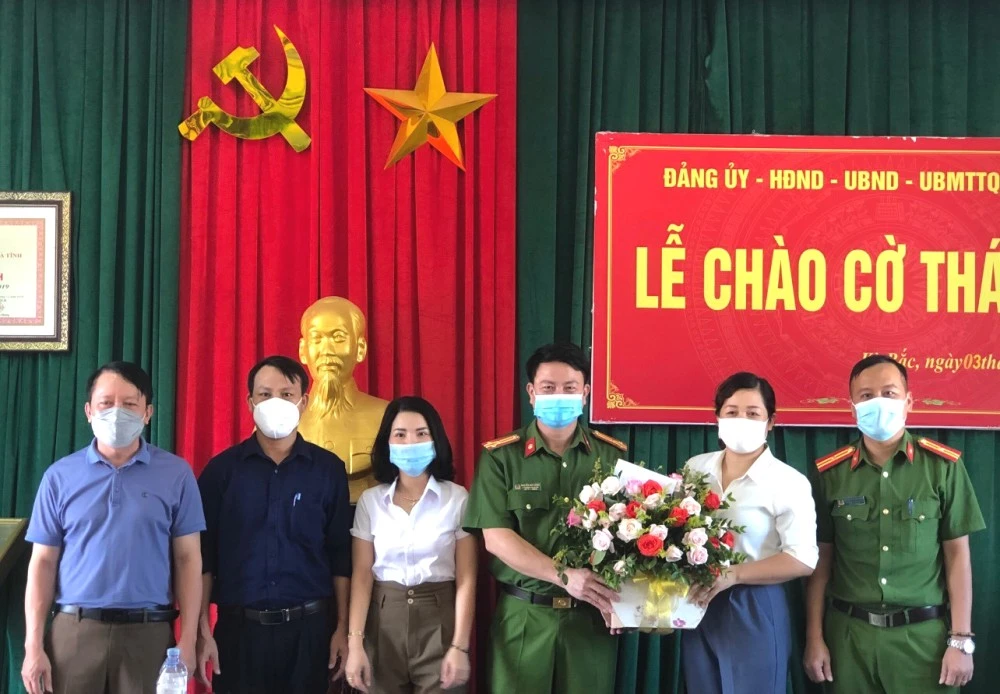 Lãnh đạo Công an huyện Kỳ Anh và xã Kỳ Bắc tặng hoa khen thưởng chị Thiều Thị Ba. Ảnh: Công an huyện Kỳ Anh cung cấp