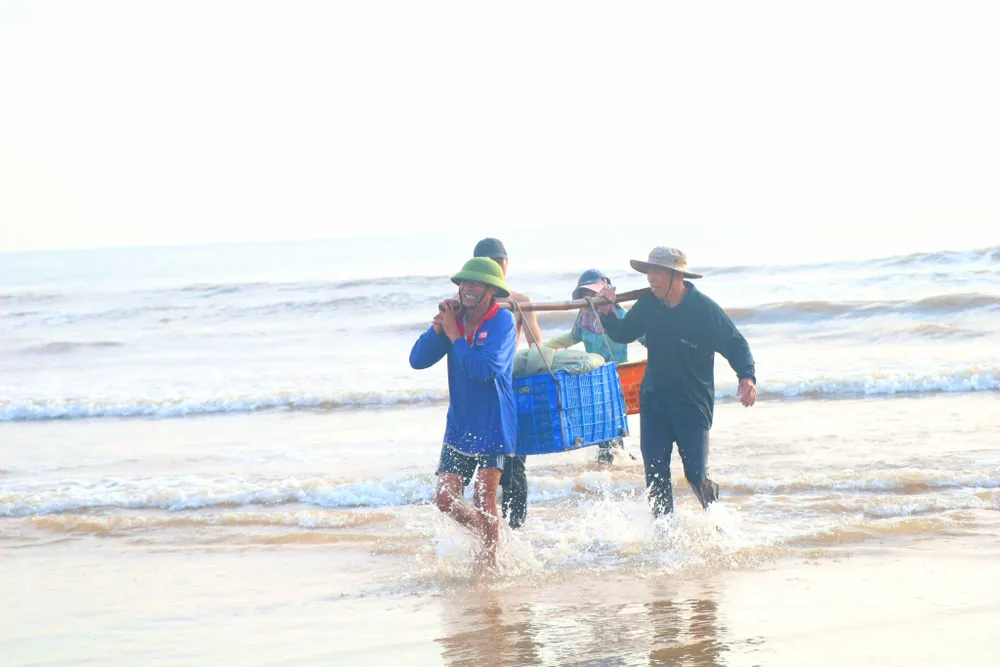 Ngư dân gánh cá từ tàu vào bờ