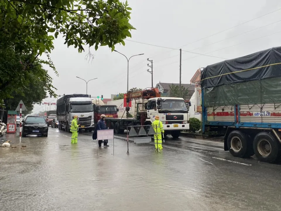 Lực lượng Công an Hà Tĩnh đội mưa hướng dẫn, phân luồng giao thông trên Quốc lộ 1A qua thị trấn Nghèn (huyện Can Lộc, Hà Tĩnh)