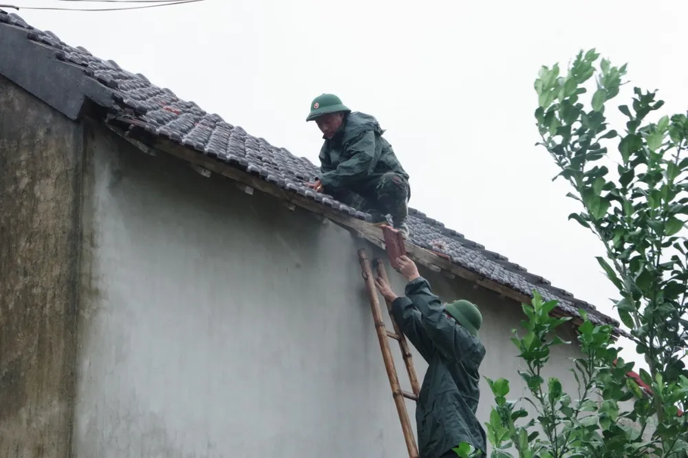 Giúp dân lợp lại mái ngói hư hỏng do lốc xoáy Giúp dân lợp lại mái ngói hư hỏng do lốc xoáy