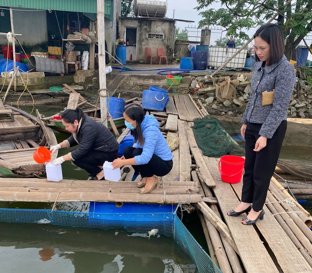 Cơ quan chức năng tiến hành lấy mẫu nước tại hồ nuôi có cá chim chết để gửi đi phân tích 