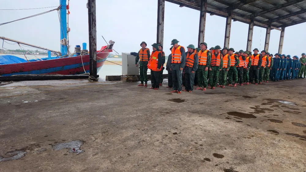 Cán bộ chiến sĩ Đồn Biên phòng Lạch Kèn cùng lực lượng chức năng triển khai hỗ trợ ngư dân neo đậu tàu thuyền tại cảng cá Xuân Hội, Hà Tĩnh z6826386573031_59078f20ced67b89464d20681bf112d1.jpg