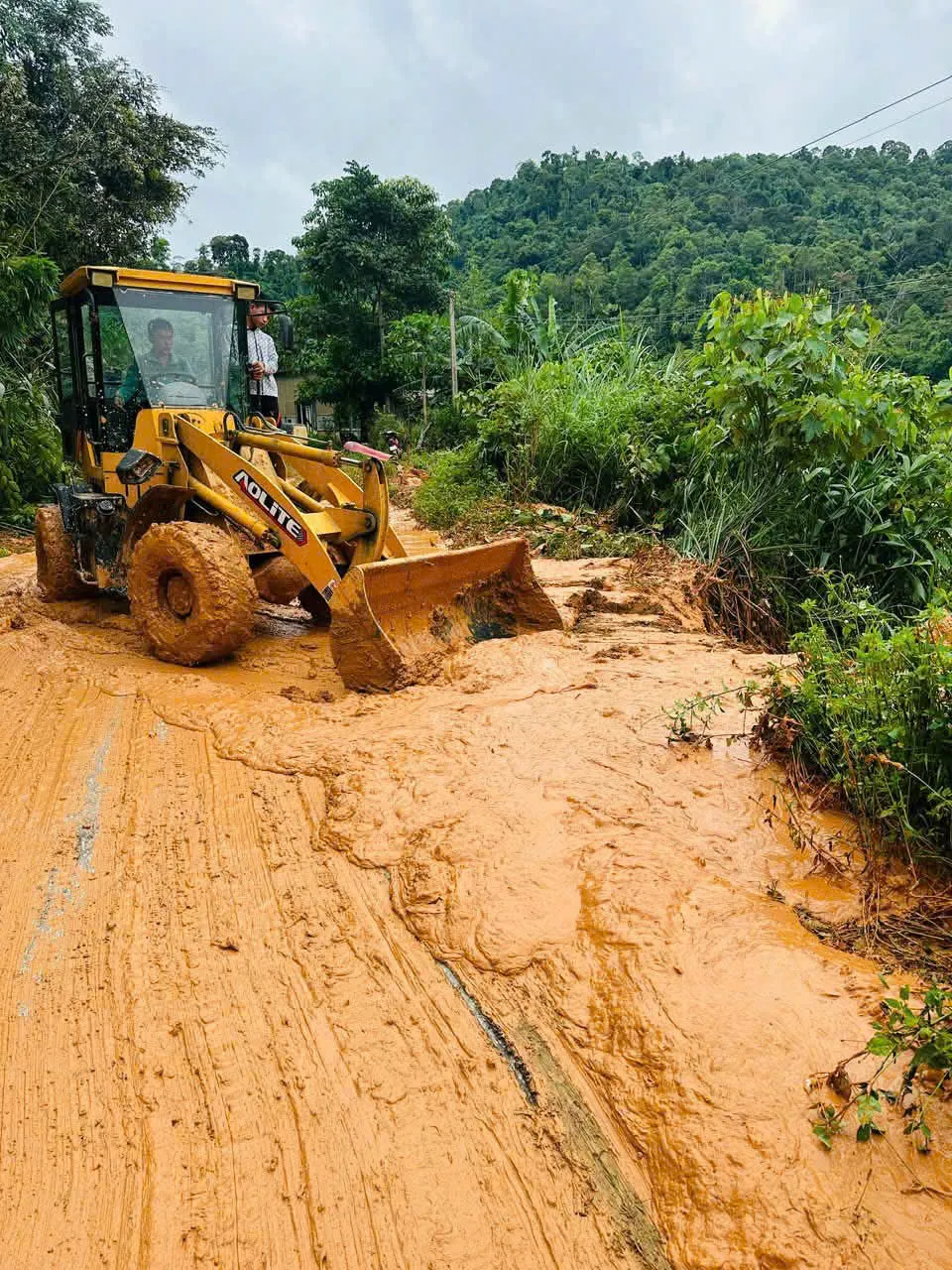 Lực lượng chức năng và người dân đang dọn dẹp bùn đất sạt lở trên đường z6832990381941_cd159838413e591e784a69c345282a0d.jpg