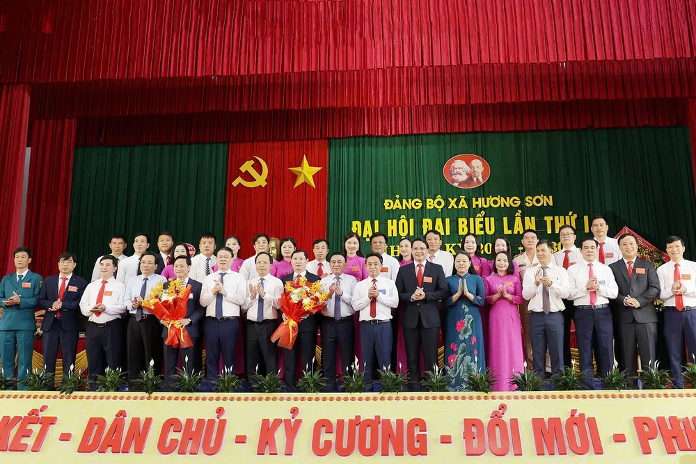 Đồng chí Trần Cẩm Tú và các đại biểu tặng hoa chúc mừng Ban Chấp hành Đảng bộ xã Hương Sơn aqq.jpg