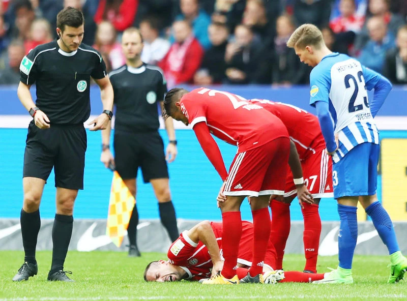 Franck Ribery ngã vật xuống sân cỏ sau khi dính chấn thương đầu gối trong trận đấu với Hertha Berlin. Ảnh: Getty Images