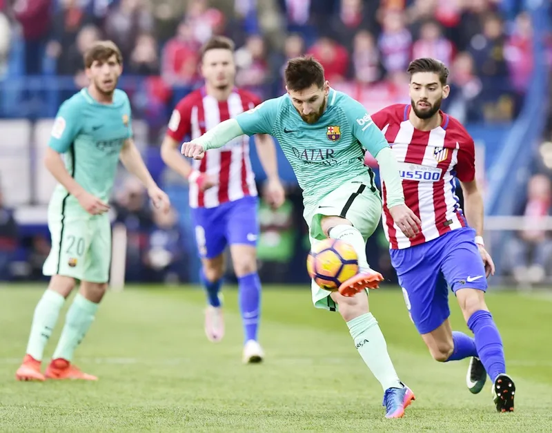 Atletico (đỏ trắng) cần phải tìm cách phong tỏa Messi. Ảnh: Getty Images