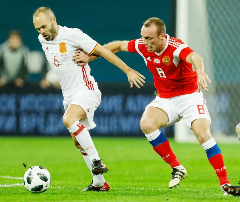 Denis Glushakov (phải, Nga) tranh bóng với Andres Iniesta (Tây Ban Nha). Ảnh: Getty Images