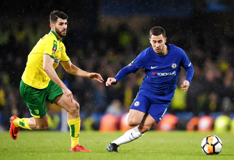 Eden Hazard (phải) nỗ lực đi bóng trước Nelson Oliveira (Norwich). Ảnh: Getty Images