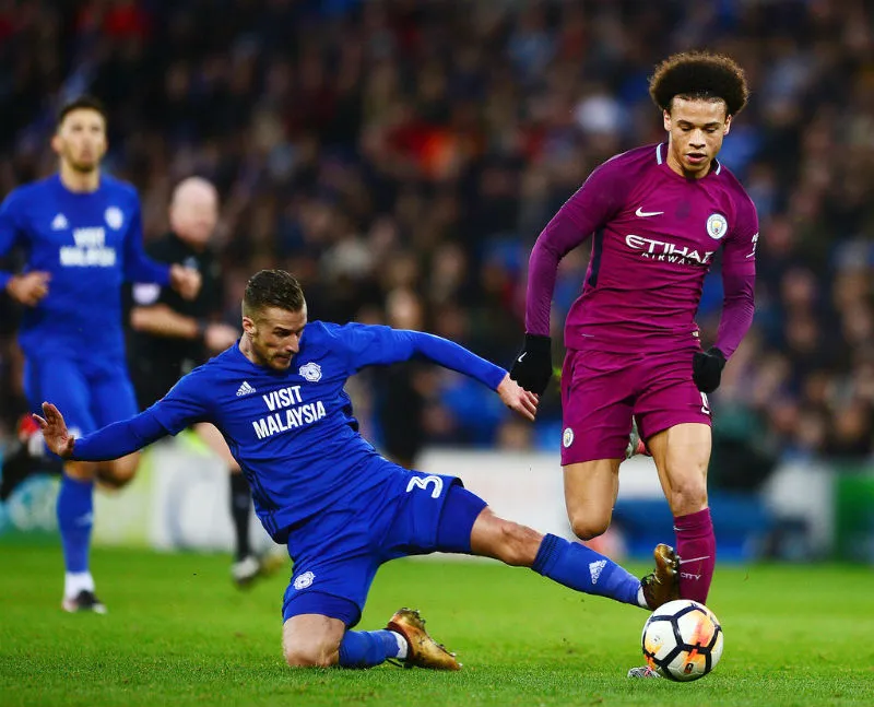 Leroy Sane (phải) phải nghỉ 1 tháng sau cú đạp nguy hiểm này của Joe Bennett. Ảnh: Getty Images 