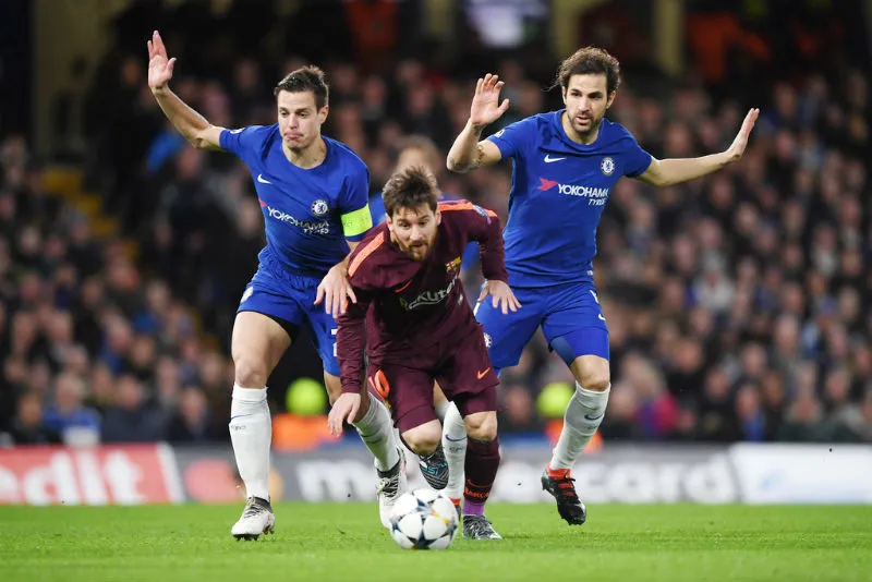 Cesc Fabregas (phải) cùng đồng đội trong nỗi lực ngăn cản Lionel Messi ở lượt đi. Ảnh: Getty Images