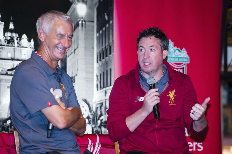 Robbie Fowler (phải) đang cố kềm nén sự bay bổng quá mức của người hâm mộ Liverpool. Ảnh: Getty Images