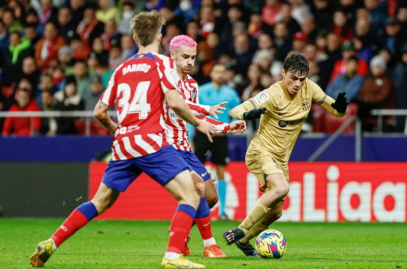Pedri (phải) trong trận đối đầu Atletico Madrid ở lượt đi.