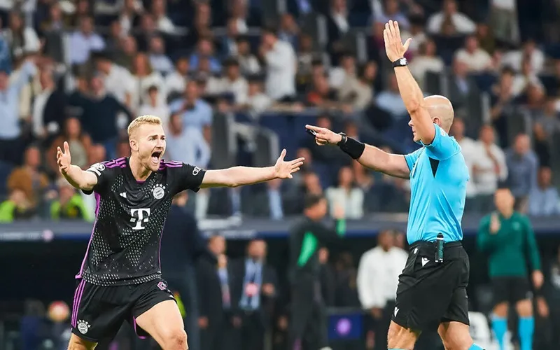 Matthijs de Ligt của Bayern Munich phản ứng với quyết định của trọng tài Szymon Marciniak.
