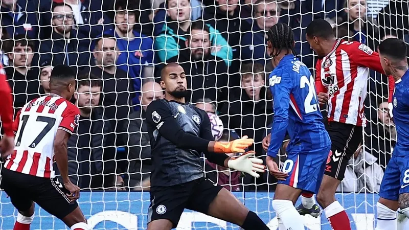 Isidor chớp thời cơ đưa bóng qua tay thủ thành Sanchez (Chelsea)