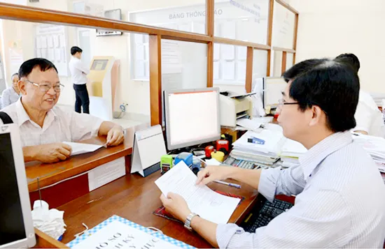 Cán bộ hướng dẫn thủ tục hành chính cho người dân ở UBND quận 7. Ảnh: VIỆT DŨNG