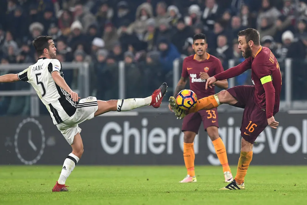 Miralem Pjanic (trái, Juventus) so giày với Daniele De Rossi (Roma).