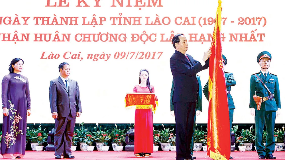 Chủ tịch nước Trần Đại Quang gắn Huân chương Độc lập hạng nhất lên cờ truyền thống của tỉnh Lào Cai